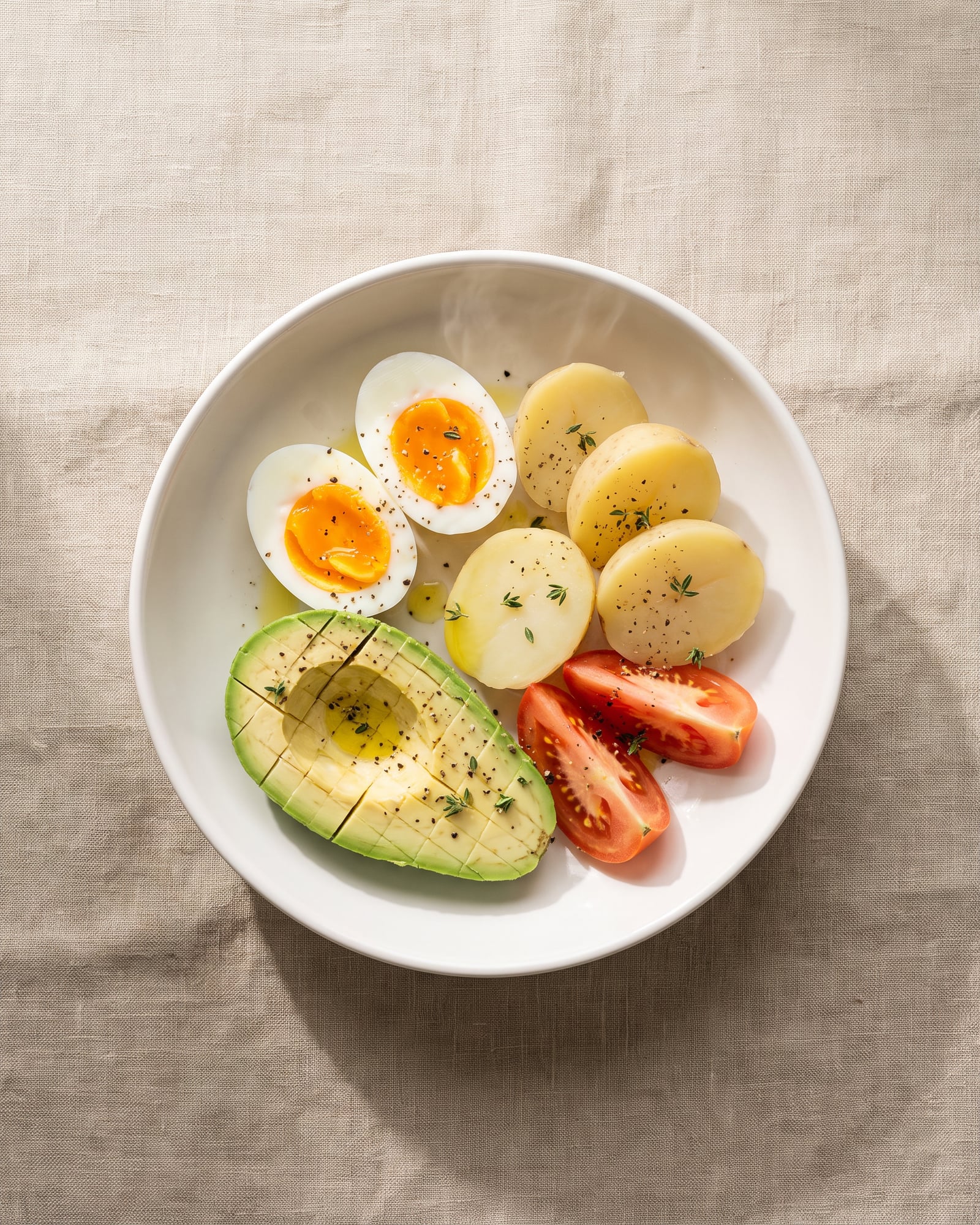 Soft-boiled eggs with new potatoes, avocado, tomato and thyme.